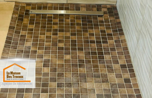 Douche à l’italienne moderne – Zoom sur le receveur à carreaux antidérapants et la rigole de drainage, garantissant une évacuation efficace de l’eau et une sécurité optimale.