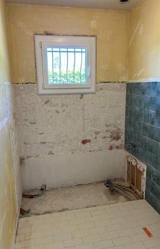 Préparation des murs et dépose des anciens revêtements avant la pose des nouveaux matériaux.