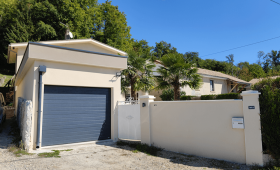Nouveau garage avec porte sectionnelle gris anthracite et façade rénovée à Saint-Cassien.