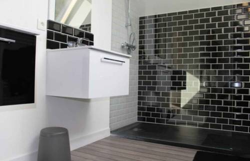 douche avec carrelage noir et un parquet en bois