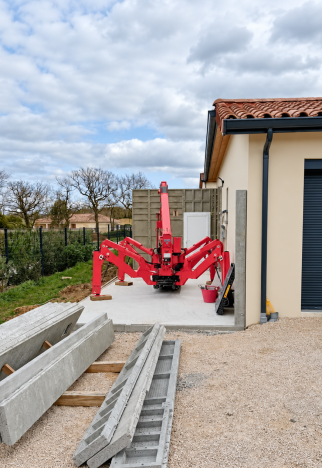 Éléments préfabriqués en béton et engin de levage pendant le montage du garage.