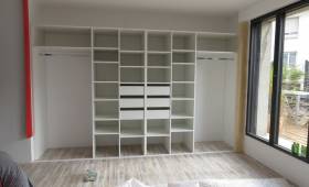 Structure intérieure d'un dressing d'entrée sur mesure avec penderies doubles et rayonnages optimisés.