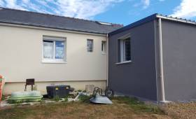 Vue arrière d’une maison à Hyères rénovée avec isolation thermique par l’extérieur, extension grise et façade principale claire.