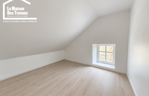 Pièce sous toiture avec plancher bois ancien et petite fenêtre dans une maison à Arzon