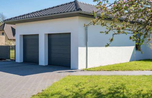 garage blanc avec un grand jardin vert