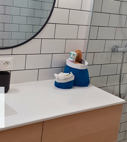 La première image montre une salle de bain moderne avec un lavabo blanc, des accessoires de bain sur le comptoir et un grand miroir rond