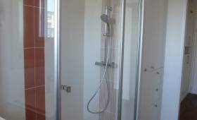 Salle de bain carrelée avec cabine de douche