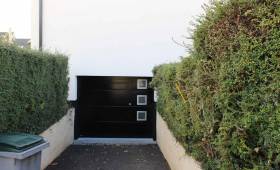 porte de garage sectionnelle noire à hublots