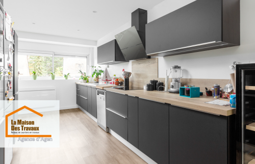 Rénovation de cuisine à Layrac : Transformation moderne avec meubles noirs et plan de travail en bois. Une cuisine élégante et fonctionnelle.