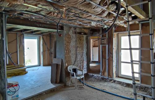 Installation de laine minérale au plafond et préparation des doublages intérieurs lors de la rénovation d'une maison ancienne près de Voiron.
