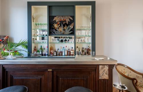 Rangement moderne pour bouteilles et verres dans un appartement haussmannien.