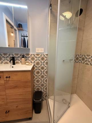 Salle de bain moderne à Paris 18, meuble vasque bois et douche vitrée
