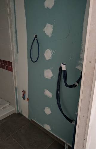 Préparation des réseaux de plomberie avant installation du meuble vasque dans une salle de bain à Voiron.