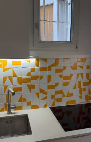 Rénovation cuisine Paris, crédence en carreaux graphiques orange et blanc, vue d'ensemble