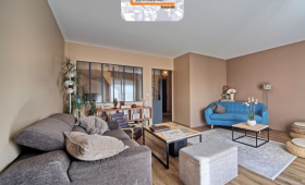 Salon rénové à La Roche-sur-Foron avec verrière intérieure, parquet bois clair et mobilier moderne – projet signé La Maison Des Travaux Bonneville