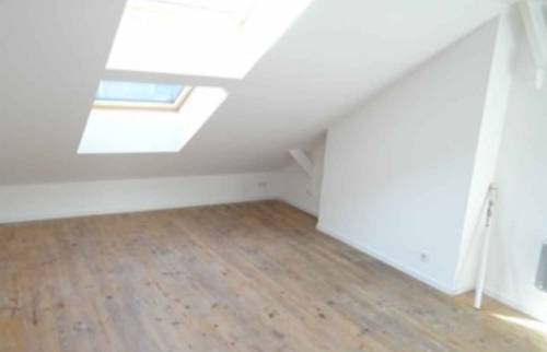 Une chambre mansardée bien éclairée