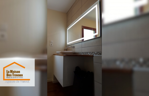 Plan de travail en bois et vasque contemporaine avec miroir LED. Une rénovation signée La Maison Des Travaux Vesoul.