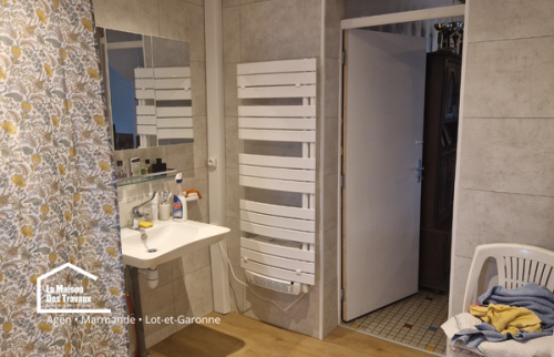 Salle de bain rénovée avec lavabo accessible, sèche-serviettes et circulation améliorée pour plus de confort et d’autonomie.