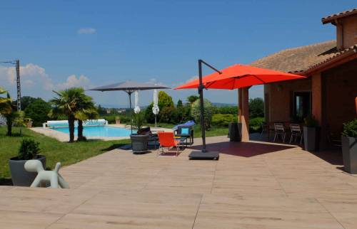 Réalisation d'une terrasse et d'une plage de piscine en dalles gres cérame posées sur plots, maison à Dommartin