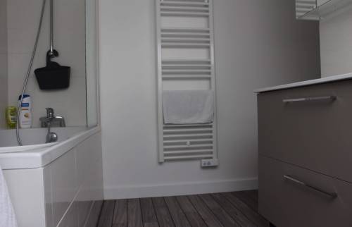 Salle de bain moderne avec sèche-serviette électrique et meuble vasque