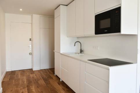 Cuisine ouverte blanche avec électroménager intégré, rénovation Paris 17