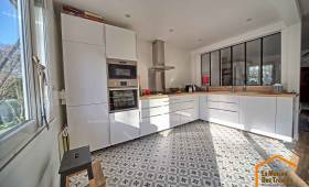 Cuisine moderne rénovée avec meubles blancs et sol graphique après transformation complète