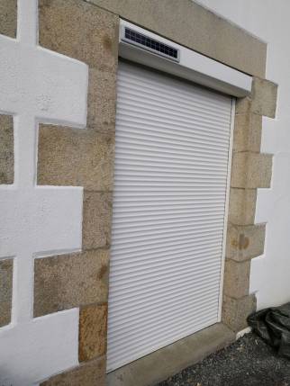 Volet roulant électrique solaire à télécommande sur la nouvelle porte fenêtre PVC double vitrage