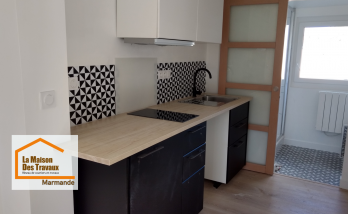 Rénovation complète d’une cuisine pour la location à Marmande : mobilier noir et blanc, plan de travail effet bois et aménagement optimisé par La Maison Des Travaux.