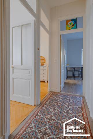 Découvert sous un ancien lino, le couloir en carreaux ciments rénovés révèle le cachet de cet appartement ancien du quartier historique de Lyon Croix Rousse