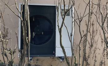 Installation extérieure, discrète, derrière la maison et camouflée par les arbustes