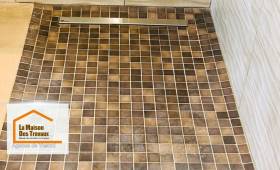 Détail du receveur de douche à l’italienne en mosaïque antidérapante, avec caniveau inox discret, réalisé par La Maison Des Travaux de Vesoul.