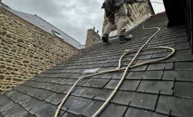 Intervention en toiture avec mise en sécurité par cordage, réalisée par un couvreur spécialisé dans les travaux en hauteur afin d’accéder à la zone d’infiltration.