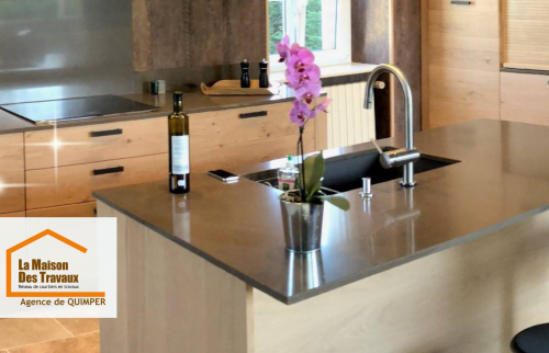 Plan rapproché sur l’îlot central avec robinetterie design et plan de travail en finition mate.