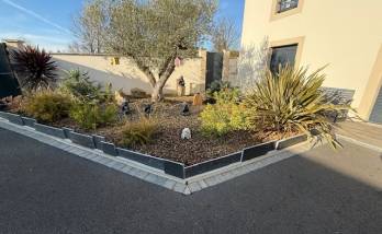 Aménagement d’une cour à Cabourg : enrobé drainant et massifs structurés