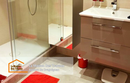 Une douche moderne avec un receveur plat, offrant un accès facile et sécurisé.