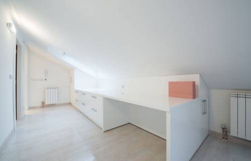 Bureau blanc laqué sur mesure optimisant l'espace sous pente dans une chambre à Méricourt.