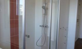 Salle de bain carrelée avec cabine de douche