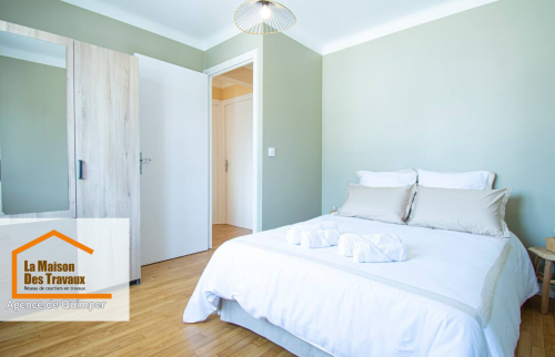 Chambre principale moderne et reposante : Une chambre lumineuse avec des teintes vertes et un mobilier élégant pour une ambiance zen.