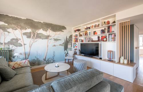 Bibliothèque blanche intégrant un espace pour la télévision et des placards