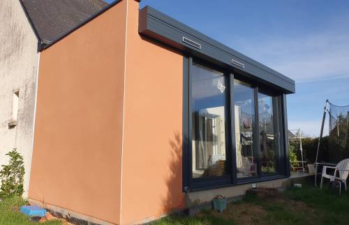 Salon spacieux et lumineux après l'installation de la véranda : projet d'extension réussi