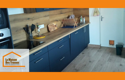 Cuisine rénovée à Ste Bazeille avec meubles bleu nuit, plan bois et électroménager intégré pour un style contemporain.