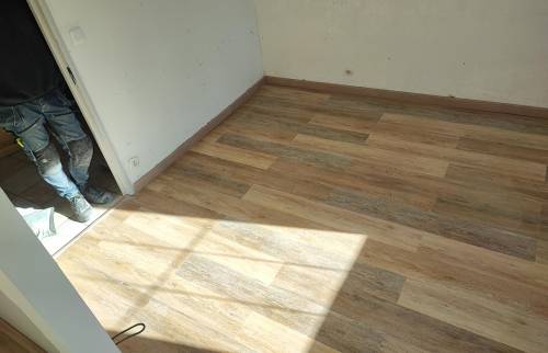 Nouveau revêtement de sol en parquet bois clair dans l'extension du salon à Carvin.