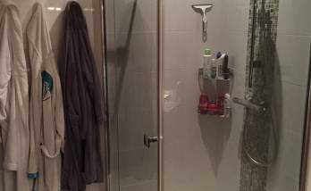 Cabine de douche avec sol en galet et faïence murale