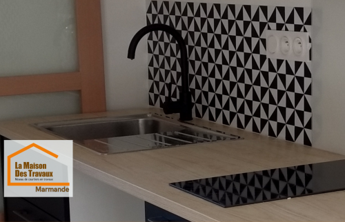 Aménagement d’une cuisine moderne pour location à Marmande avec évier intégré, plaque de cuisson et crédence graphique réalisée par La Maison Des Travaux.