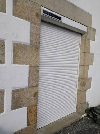 Volet roulant électrique solaire à télécommande sur la nouvelle porte fenêtre PVC double vitrage