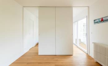 Porte cachée derrière une bibliothèque dans un salon moderne à Paris 16e.