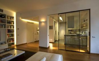 Cuisine ouverte ou fermée sur le salon grâce à ces portes coulissantes en verre.