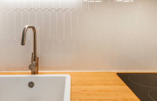 Évier blanc contrastant avec des placards verts modernes