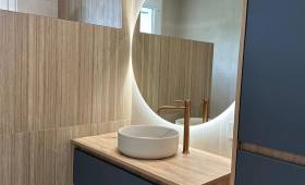 Meuble vasque suspendu sur mesure, miroir rétroéclairé et ambiance chaleureuse pour cette salle de bain rénovée à Voiron.