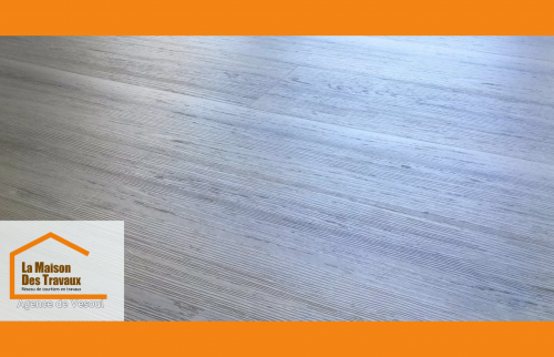 Détail du sol stratifié à l’effet bois naturel, sélectionné pour sa résistance et son esthétique.